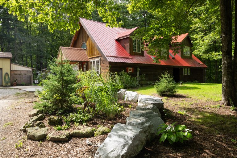 Lovely log home on a park-like 3.51 acre wooded lot in Norfolk.